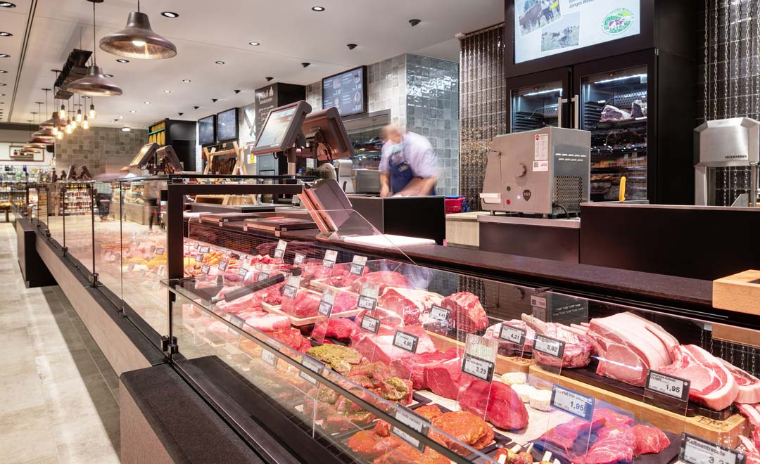 Bancone prodotti freschi dedicato a carne e salumi, illuminato con il proiettore incassato Agira Plus e l'apparecchio a sospensione Limba.