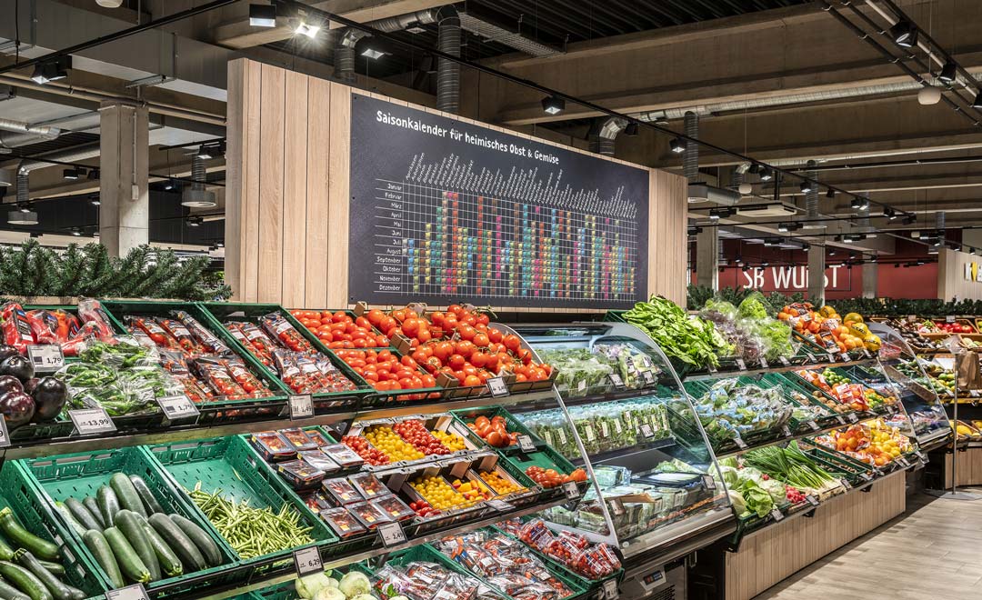 Scaffale al margine del reparto frutta e verdura illuminata con il proiettore Kalo.