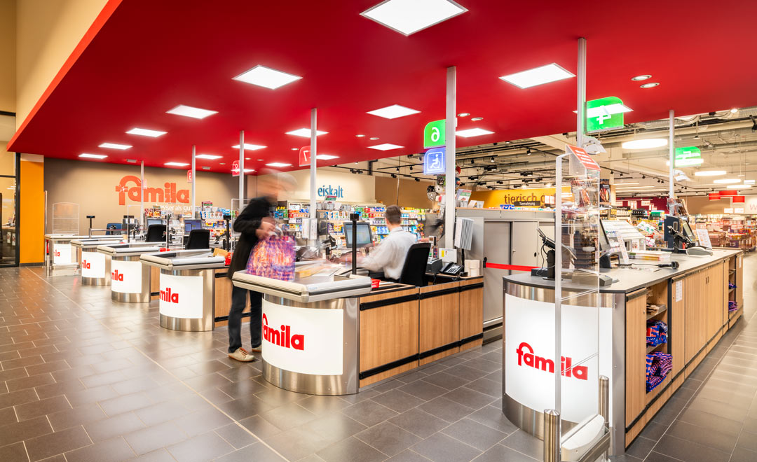 Human Centric Lighting dans la zone des caisses du Famila Trittau – le matin avec une ambiance lumineuse chaleureuse adaptée à la lumière du jour. 