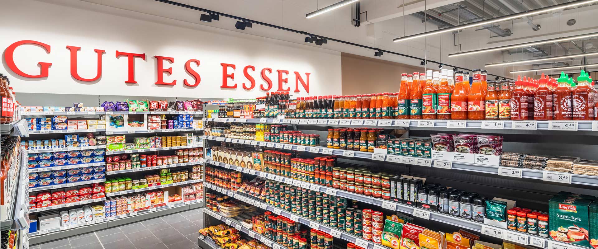 Assortimentsgang met droge voeding, verlicht met E-Line Next LED en graphics-verlichting met Grado. 